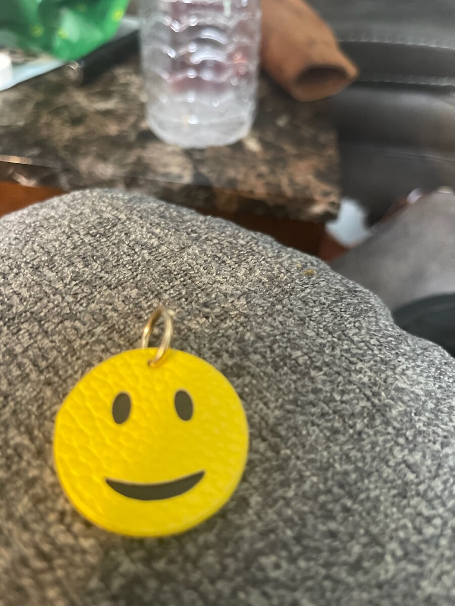 A smiley face Keychain in mail • Report Issues. Protect your community